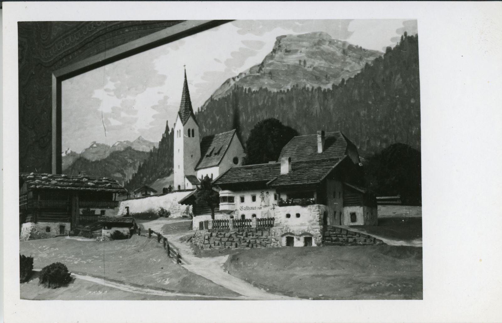 Kirche mit Bauernhöfen in gebirgiger Landschaft